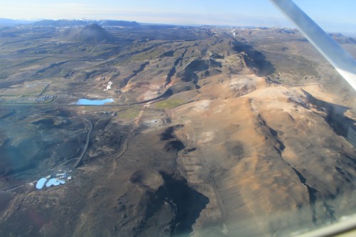 Berg Namafjall mit Pass Námaskarð und Myvatn Naturbad. Im Hintergrund sieht man das Krafla-Kraftwerk dampfen.